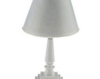 Könnte beinhalten: Kleine, weiße Tischlampe mit konischem Lampenschirm. Die Lampe hat einen dekorativen Sockel und einen schlanken Stiel. Die Lampe ist eine Miniaturgröße, geeignet für ein Puppenhaus oder andere kleine Projekte, ca. 10 cm hoch.