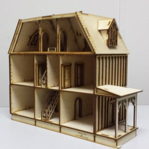 May include: A wooden dollhouse with a white paint finish. The dollhouse is open and shows the interior rooms and a staircase. The dollhouse has a porch with a decorative railing.