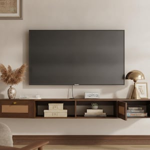 May include: A wall-mounted dark wood media console featuring a left-side drawer with a cane-textured panel, an open center storage section, and a right-side cabinet with a matching cane-textured door, positioned beneath a large flat-screen television.