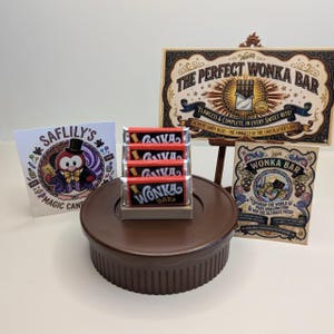 May include: A stack of four Wonka chocolate bars on a brown circular stand, accompanied by two rectangular signs with ornate borders and text, and a square card featuring a cartoon penguin in a top hat and bowtie labeled Saflily's Magic Candy.