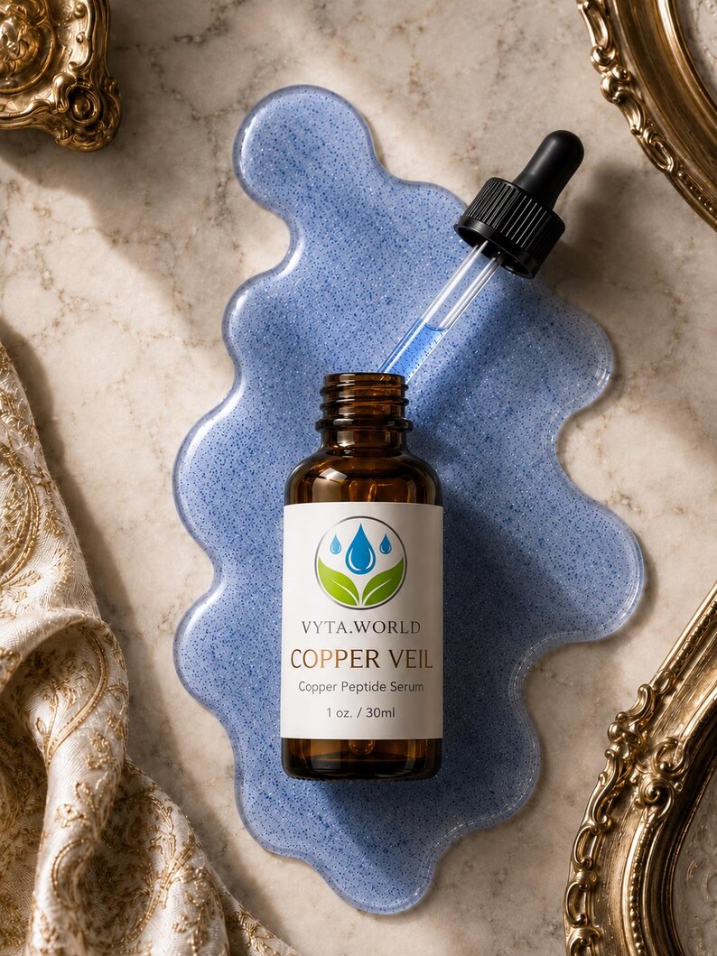 May include: An amber glass bottle of Vyta.World Copper Veil Copper Peptide Serum, 1 oz. / 30ml, with a black dropper cap. The bottle sits on a blue, translucent, irregular-shaped puddle of serum, with a glass dropper extended above the bottle.