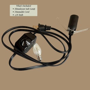 May include: A black electrical cord with a dimmable switch, a light bulb socket with metal tension clips, and a 15W light bulb. Text in the image reads: What's Included, Himalayan Salt Lamp, Dimmable Cord, 15W Bulb. The cord has a standard two-prong plug.