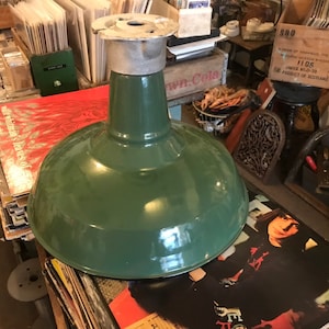 May include: A green vintage industrial style pendant light with a metal shade and a white metal socket.