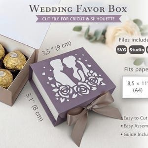 Puede incluir: Una caja de recuerdo de boda morada, archivo de corte para Cricut y Silhouette, con diseño troquelado de pareja y rosas, y un lazo color topo. La caja mide 9 cm por 8 cm. El texto incluye Wedding Favor Box, Cut File, SVG, Studio, DXF y A4.
