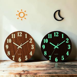 May include: Two round wooden wall clocks. One has a light brown wood grain finish with white numerals and hands. The other has a dark brown finish with glowing green numerals and hands. Both have the word "QUARTZ" printed on the face.