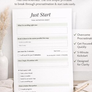 May include: A printable task initiation sheet labelled "JUST START" designed to help with procrastination. The sheet features sections for breaking down tasks, a 5-minute kickstart, and prompts to aid focus. A pen lies on a wooden surface next to the sheet.