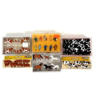 May include: A selection of miniature farm animal and figure models, including cows, horses, and people. The cows are brown and white, and black and white. The horses are brown, black, and white. The figures are dressed in various colours.