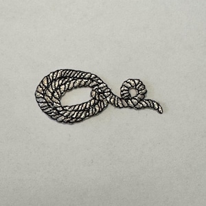 May include: A silver and black rope design embroidered patch. The rope is coiled and tied in a knot.