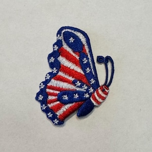 May include: A red, white, and blue butterfly-shaped embroidered patch with a star pattern.