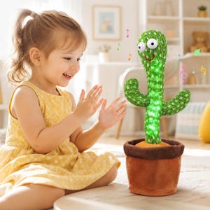 May include: A plush cactus toy with a green knitted texture, large white googly eyes, and a stitched red smile. The cactus is planted in a brown fabric pot and features internal lights, with colorful musical note icons floating around it.