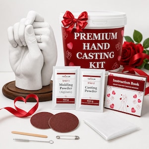 May include: A premium hand casting kit featuring a white bucket with a red bow, two packets labeled Molding Powder 700g and Casting Powder 1100g, an instruction book, two brown sanding discs, a wooden stick, a cleaning brush, and a metal pin.