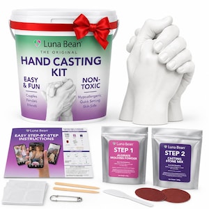 May include: A Luna Bean hand casting kit featuring a white bucket with a red bow, a white plaster hand sculpture, an instruction booklet, two silver foil pouches labeled Step 1 and Step 2, wooden sticks, a plastic spatula, sandpaper, and a pin.