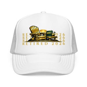 May include: White trucker hat with a gold graphic of a wooden chair, table, and the word "MONEY" on a small sign. The text "RETIRED 2026" is printed in gold on the front of the hat.