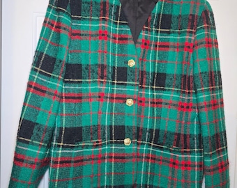May include: A Pendleton brand blazer featuring a green, black, and red plaid pattern. The jacket has a V-neckline, long sleeves, and three gold-toned circular buttons down the front. It is lined with black fabric and hangs on a black hanger.