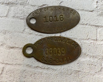 May include: Two oval-shaped brass tags with numbers and company names. The top tag reads "PROP OF ULH&P.CO 1016 RE. TOLO". The bottom tag reads "PROP OF C.G&E.CO 33039 632-3341".