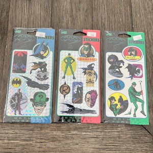 Peut inclure: Trois paquets d'autocollants Batman Forever. Chaque paquet pr&eacute;sente un personnage diff&eacute;rent du film&nbsp;: Batman, Robin et l'Homme-Myst&egrave;re. Les autocollants sont holographiques et ont un fond argent&eacute;. Les paquets sont &eacute;tiquet&eacute;s avec le titre du film et le nom du personnage.