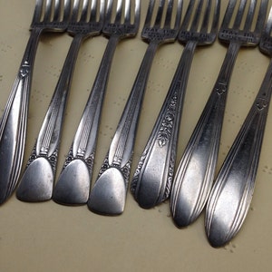 May include: Eight silver forks with ornate designs and the inscription "May the Forks Be With You".