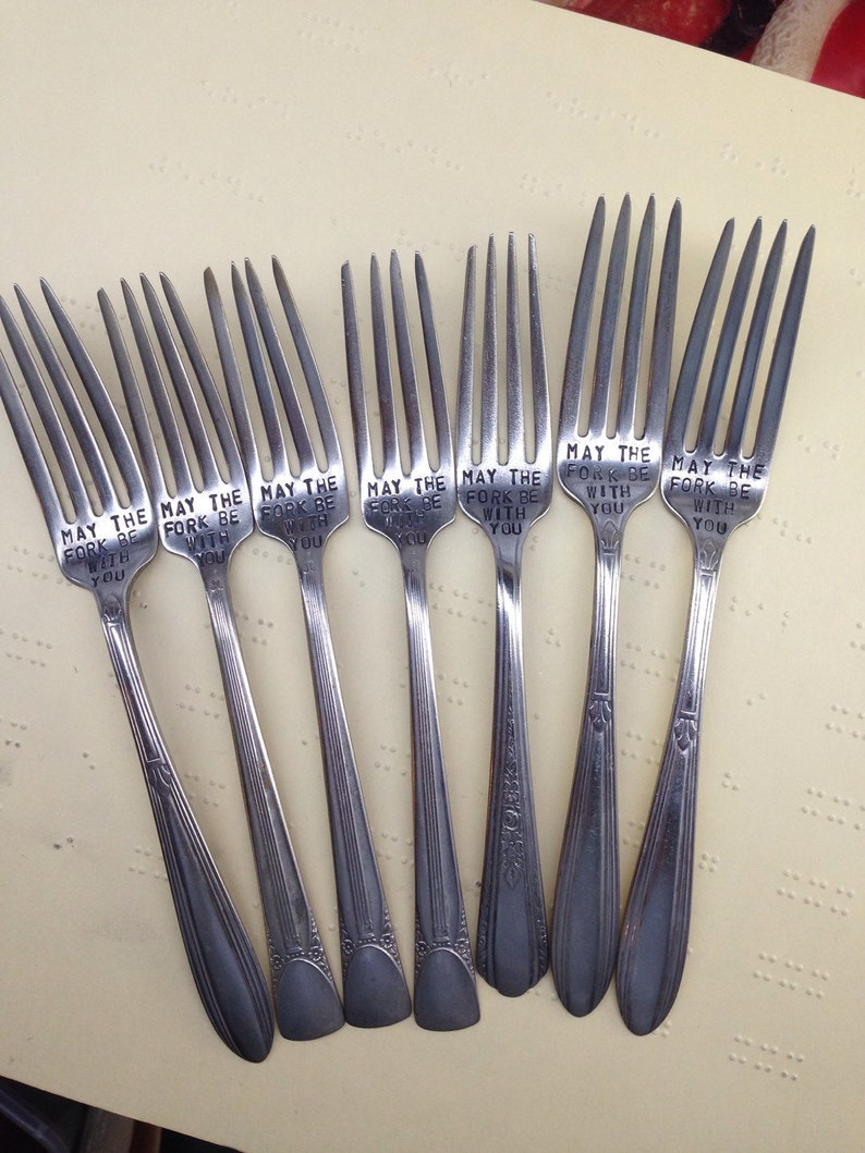 May include: A set of eight silver forks with the phrase "May the fork be with you" engraved on each one.