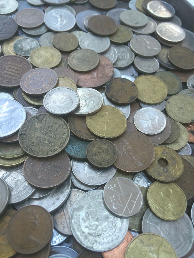 May include: A collection of vintage coins in various denominations and metals, including copper, silver, and gold. The coins are arranged in a random pattern, with some overlapping. The coins are in good condition, with some showing signs of wear and tear.