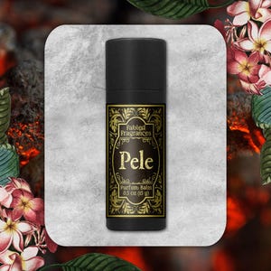May include: A black cylindrical tube of Fabled Fragrances Pele parfum balm. The label features gold ornate filigree borders, the text Fabled Fragrances, Pele, and 0.5 oz (15 g) printed in a clear, legible font against a dark background.