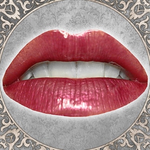 May include: Close-up of a pair of lips wearing a glossy, deep red lipstick. The lips are slightly parted, revealing a row of white teeth.