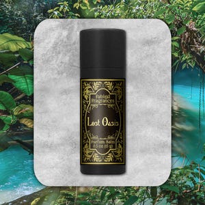Könnte beinhalten: Eine schwarze Tube mit einem goldenen Etikett, auf dem "Fabled Fragrances Lost Oasis Perfume Balm 0.5 oz (15 g)" steht.
