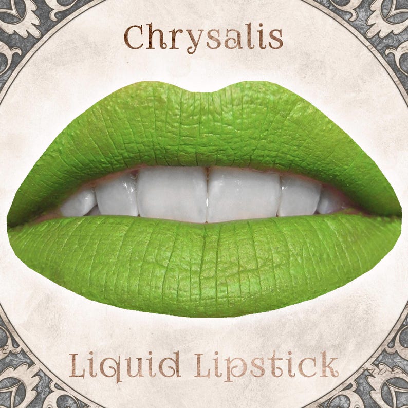 May include: A pair of lips coated in a vibrant, matte lime green liquid lipstick. The word Chrysalis is printed in brown above the lips, and the words Liquid Lipstick are printed in brown below the lips, all set within a circular frame.