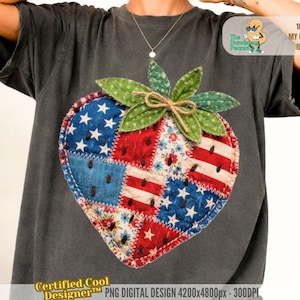 Pode incluir: Camiseta cinza escuro com um design de morango em patchwork. O morango é composto por peças de tecido vermelho, branco e azul, incluindo estrelas e listras. O design inclui folhas verdes e um laço de barbante marrom. A camiseta tem o texto "Certified Cool Designer".