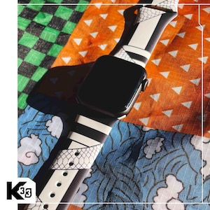 May include: A black smartwatch with a patterned band featuring white, black, and gray geometric designs. The watch is displayed on a colorful patchwork background with orange, blue, and green patterns.