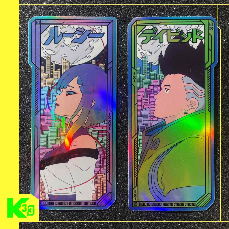 May include: Two holographic stickers with anime-style characters. One shows a woman with blue hair, the other a man in a green jacket. Both have Japanese text and cityscapes. The stickers have a rainbow sheen and are rectangular.