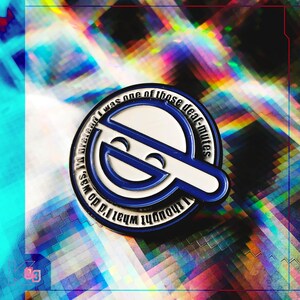 May include: A blue and white enamel pin with a stylized smiling face design. The pin has a circular shape with a white outline and blue accents. Text around the edge reads "I thought what I'd do was pretend I was one of those deaf-mutes."