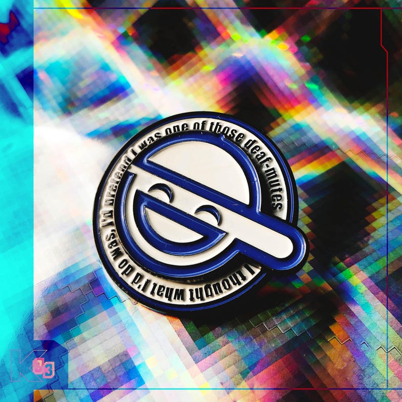 May include: A blue and white enamel pin with a stylized smiling face design. The pin has a circular shape with a white outline and blue accents. Text around the edge reads "I thought what I'd do was pretend I was one of those deaf-mutes."