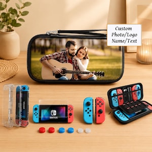 Puede incluir: Un estuche de transporte rectangular negro con una foto personalizada de una persona tocando la guitarra, junto a una consola Nintendo Switch, dos mandos desmontables, una funda protectora transparente y seis tapas circulares para joysticks.
