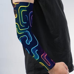 May include: An arm sleeve featuring a dark navy blue background with a vibrant, multi-colored abstract pattern of interconnected, flowing lines in shades of bright yellow, lime green, cyan, royal blue, purple, and magenta, covering the entire arm.