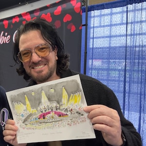 May include: A rectangular white art print featuring a colourful watercolour illustration of a concert stage at Madison Square Garden. The artwork depicts performers under bright yellow spotlights with a crowd below, including handwritten text details.