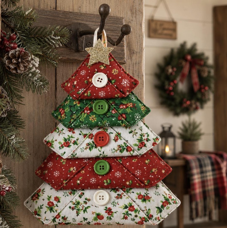 May include: A fabric Christmas tree wall hanging composed of five stacked, triangular, quilted fabric segments in red, green, and white floral patterns. Each segment features a single white, red, or green button and a gold glitter star topper.