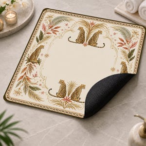 May include: A square mouse pad with a cream-coloured surface featuring a decorative border and a pattern of leopards and tropical foliage. The design includes four leopards positioned around a central blank area, with a black textured underside.