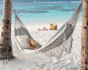 Rede de casal estilo boho, balanço de lona cinza claro, cadeira suspensa com franjas de macramê