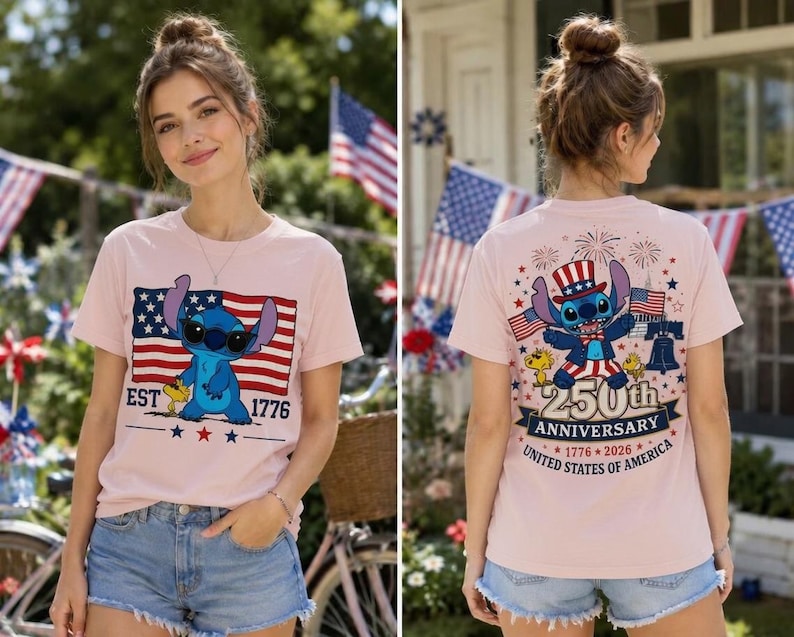 Op de afbeelding: Een lichtroze t-shirt met een afbeelding van Stitch met een zonnebril op de voorkant en de tekst EST 1776. De achterkant toont Stitch met een patriottische hoed en de tekst 250th ANNIVERSARY 1776-2026 UNITED STATES OF AMERICA.