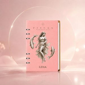 May include: A pink ring-bound planner featuring a central illustration of a woman surrounded by two fish. The text PISCES THE DREAMER OF THE SEA is printed above the figure, and the name LENA is printed in capital letters at the bottom of the cover.