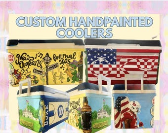 May include: Five rectangular plastic coolers featuring hand-painted designs, including New Orleans themes, American flag patterns with Greek letters, a Duke University logo, and a football player. The text CUSTOM HANDPAINTED COOLERS is at the top.