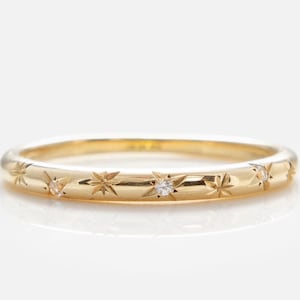 Könnte beinhalten: Ein Set aus drei Keramikbechern mit gesprenkelter, matter Oberfläche. Die Becher sind in Creme-, Hellgrau- und Dunkelgrautönen gehalten. Jeder Becher hat ein schlichtes, minimalistisches Design und einen abgerundeten Henkel.