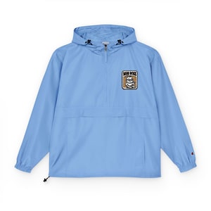 May include: A light blue anorak jacket with a hood and a half-zip closure. The jacket features a "Mini Boss" patch on the chest and a small Champion logo on the sleeve. The jacket has a drawstring at the hem.
