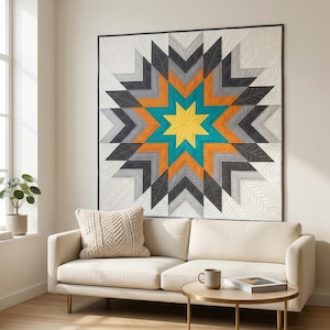 May include: A large, colorful star quilt hangs on a wall above a cream-colored sofa. The quilt features a central yellow star surrounded by teal, orange, gray, and black geometric shapes. The background is white with a subtle floral pattern.