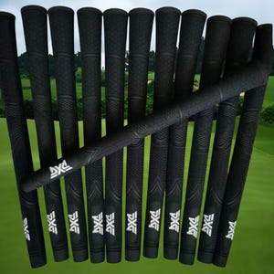 Puede incluir: Un conjunto de empuñaduras negras para palos de golf con una superficie texturizada. Cada empuñadura presenta el logotipo blanco de PXG. Las empuñaduras están dispuestas sobre un fondo de campo de golf verde.