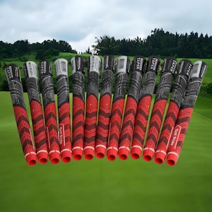 Puede incluir: Un conjunto de empuñaduras de palos de golf con un diseño rojo y negro. Las empuñaduras están dispuestas en fila, con la parte roja en la parte inferior. Las empuñaduras tienen el texto "REDUCED TAPER" y "MCC PLUS 4". El fondo es un campo de golf.