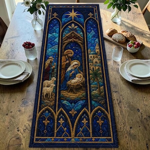 May include: A rectangular quilted table runner featuring a stained-glass style nativity scene with deep blue, gold, and teal tones. The central panel depicts a family with a newborn, sheep, and a distant city, framed by arched architectural borders.