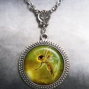 May include: A silver necklace with a round pendant featuring a vintage illustration of a fairy with wings, holding a wand, against a green and gold background.