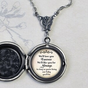 May include: Silver locket necklace with a delicate chain. The locket opens to reveal a message that reads: "We'll love you Forever We'll like you for Always As long as you're living, our Baby you'll be."