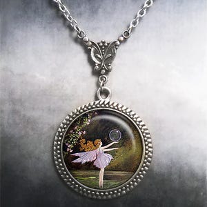 May include: Silver pendant necklace with a round charm depicting a fairy. The fairy, in a lavender dress and wings, is reaching for a bubble. The charm has a beaded edge and hangs from a delicate silver chain.